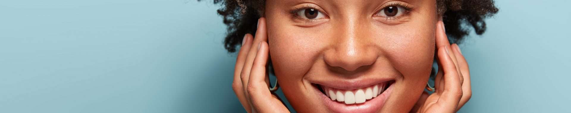 banner for face and skin treatments featuring a smiling black woman with beautiful, healthy skin