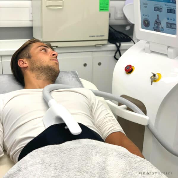 Young man on body sculpting machine for abs