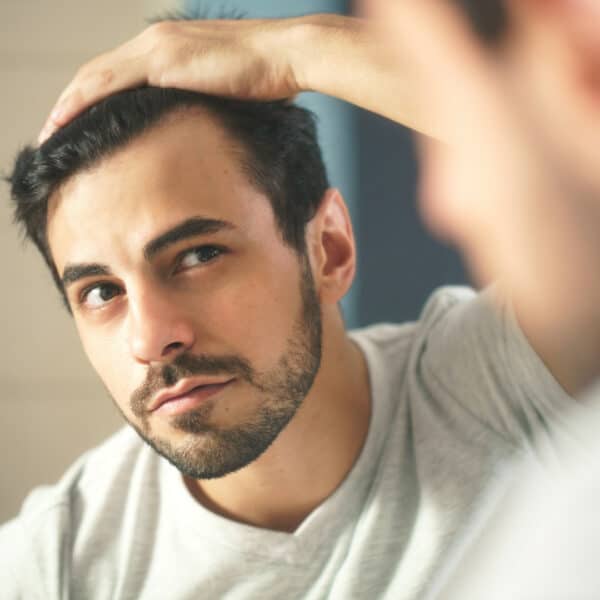 man in mirror hair loss viestem hair at vie aesthetics